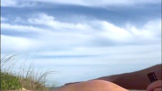 Redhead babe rests on the beach and then massages stranger's cock