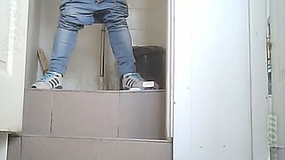 White chick in blue jeans and coat pisses in the toilet