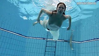Long hair solo model blonde widening legs while diving in pool