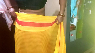 Indian housewife is wearing a yellow saree.