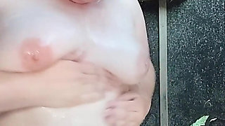 I'm watching a curvy girl wash herself in the street.