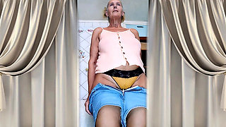 Cheerful old lady Lukerya. Alluring movements and shiny feet on the washing machine.