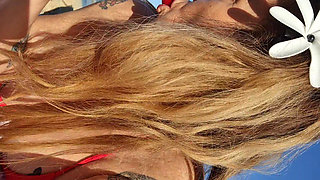 Melissa Johnson sucks and licks a cherry lollipop on the .beach